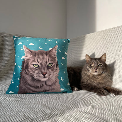 Photo of green custom pet portrait faux suede pillow with grey cat's artwork on it sitting next to the actual cat