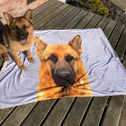 Photo of custom pet portrait fleece blanket with dog's artwork on it laying on wooden terrace while the dog is sitting on to the blanket