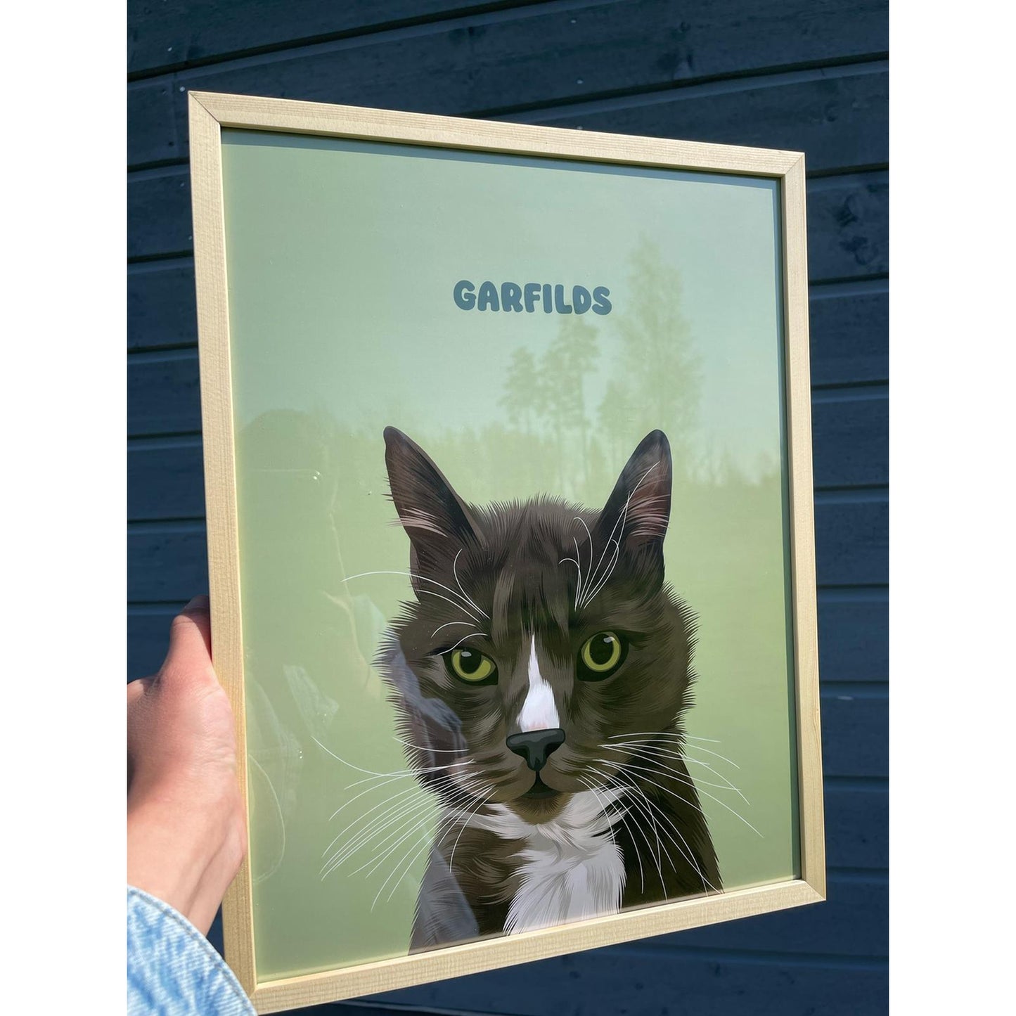 Close up photo of a custom pet portrait framed poster featuring artwork of a dark grey cat