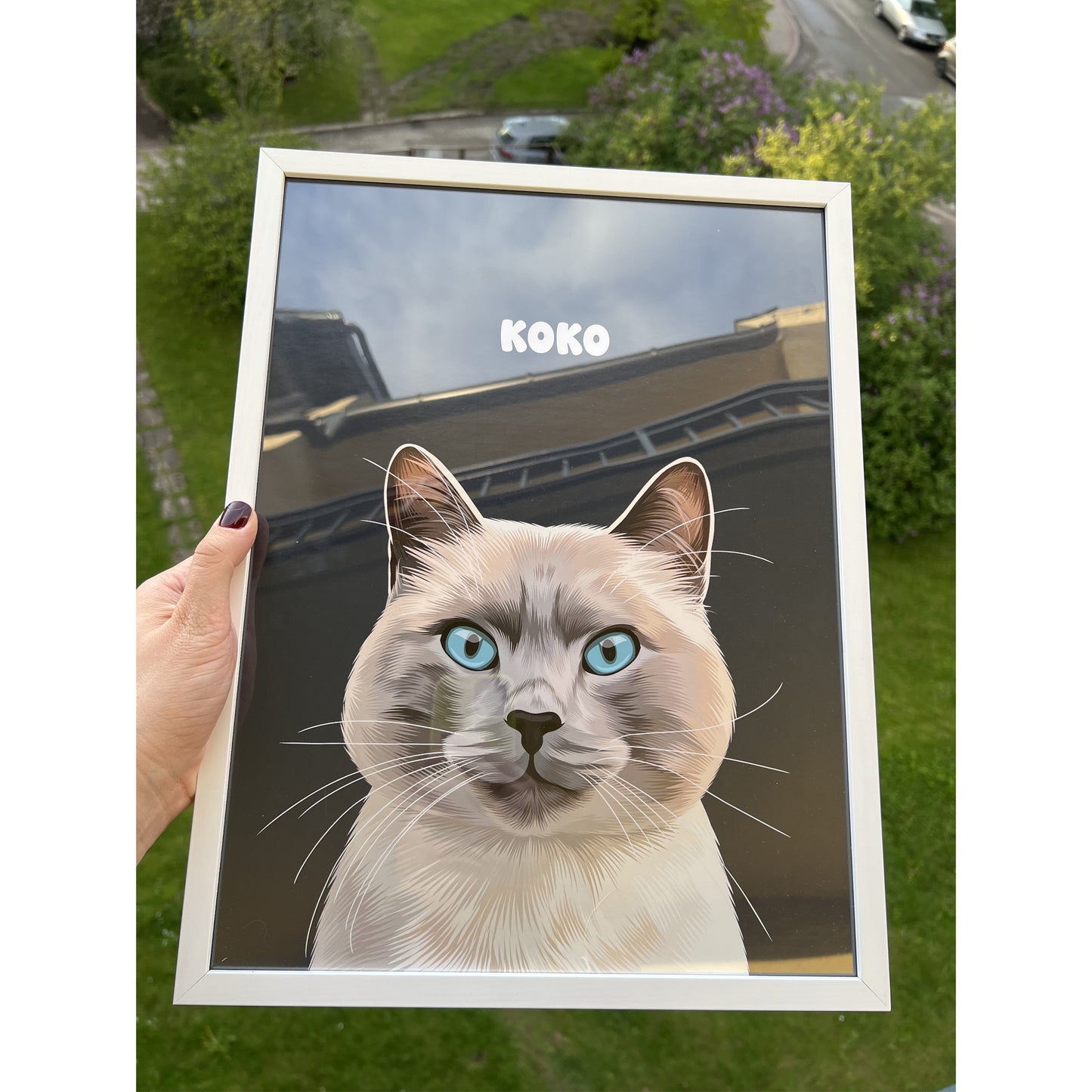 Close up photo of a custom pet portrait framed poster featuring artwork of a white and grey cat